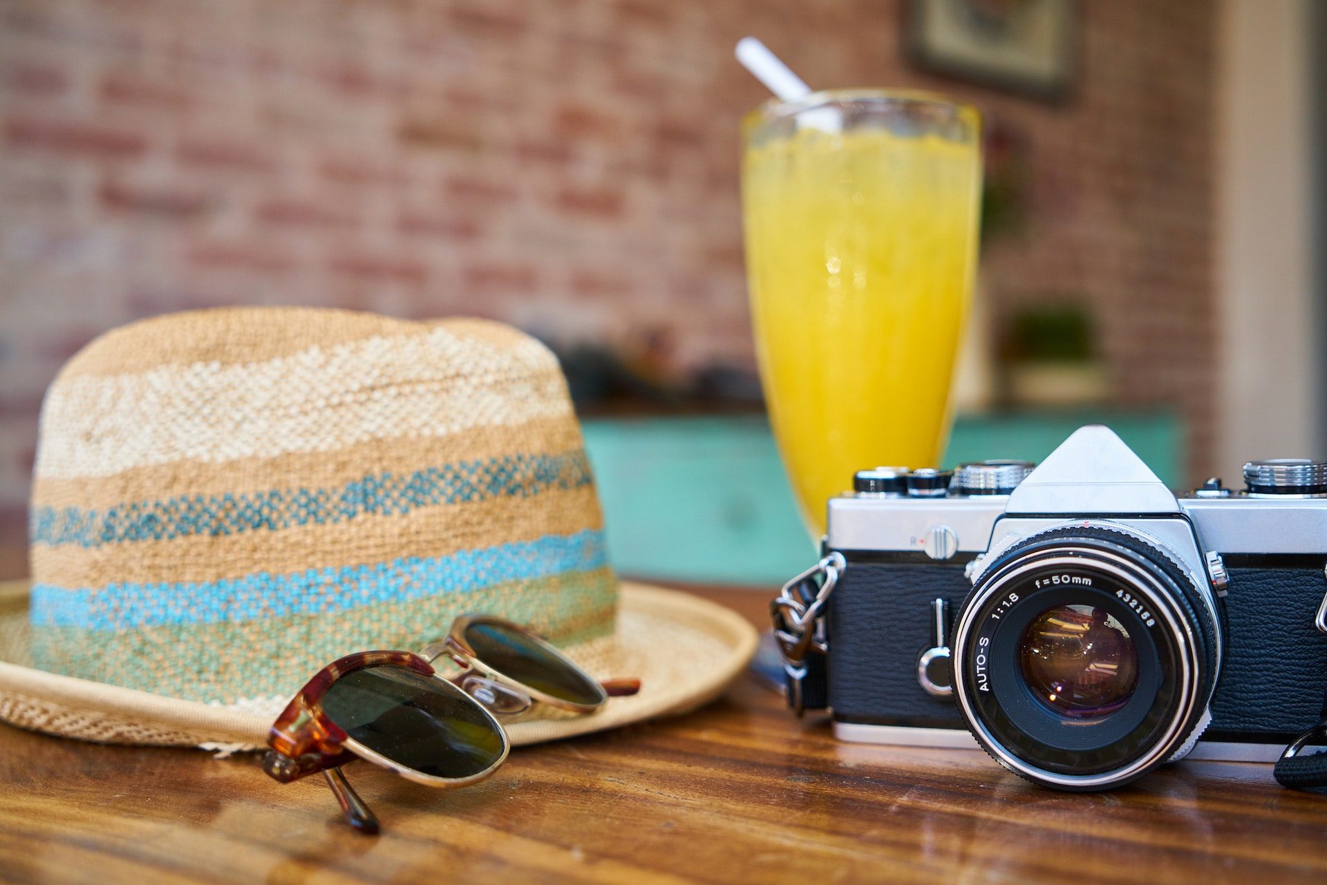 vacation hat, sunglasses, tropical drink, and camera