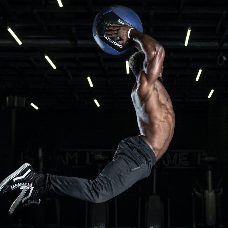 Man with exercise ball jumping in the air