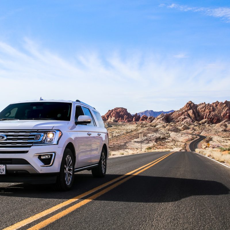 Ford SUV driving solo down the road through Nevada's Valley of Fire State Park.