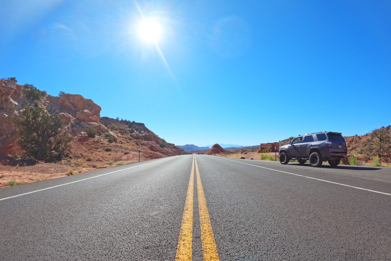 Looking down Utah Highway 24 near the Capitol Reef National Park entrance sign.
