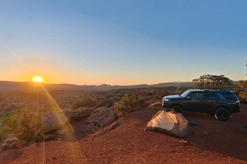 A gray Toyota 4Runner from Turo parked on a bluff overlooking the sunset in southern Utah.