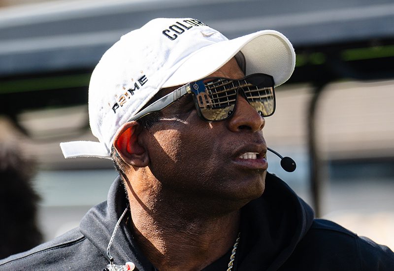 Deion Sanders wearing Blenders and mic