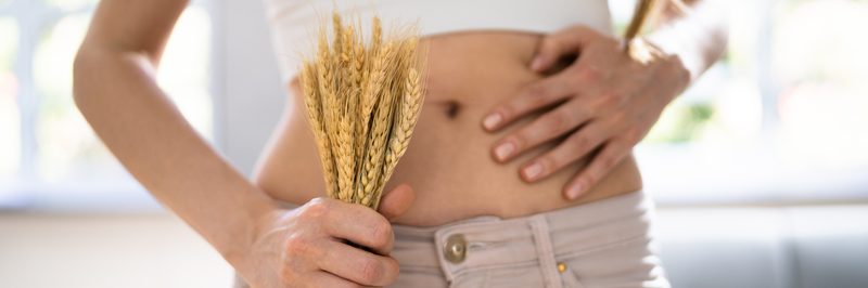 Celiac Disease And Gluten Intolerance. Women Holding Spikelet Of Wheat