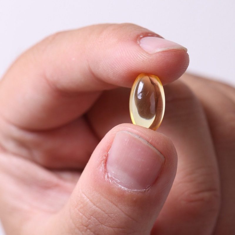 Close up photo of hand holding vitamin softgel