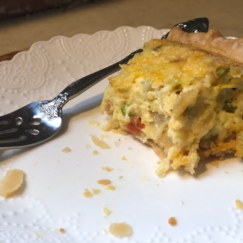 A slice of quiche on a white plate