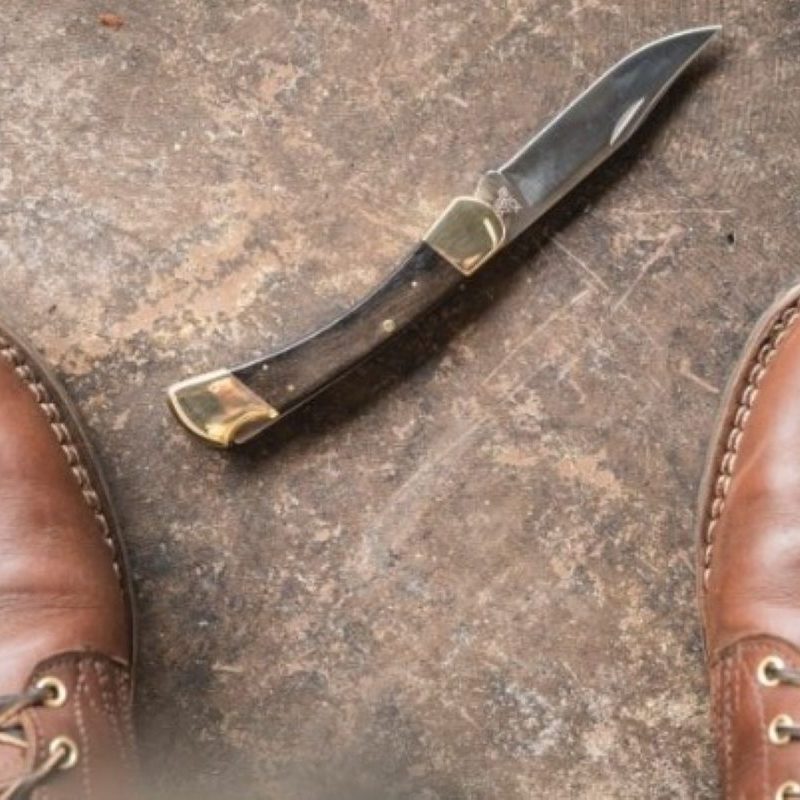 Open knife on the floor in front of boots