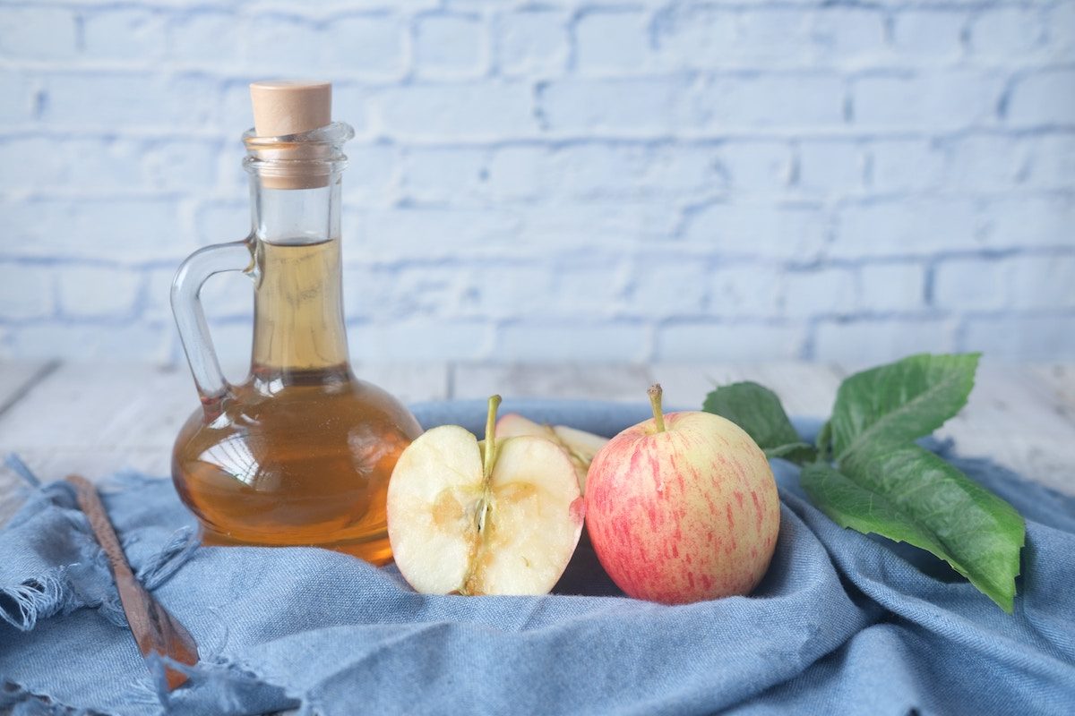 apple cider vinegar on table by glass canister