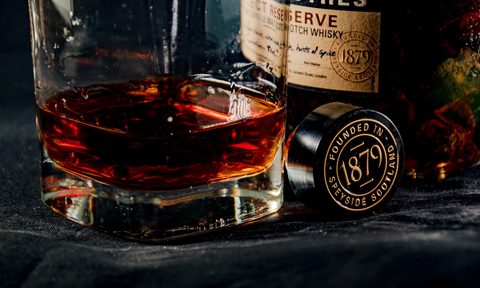 A very dark scotch in front of its bottle