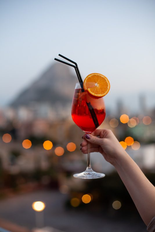Person holding a glass of Aperol spritz