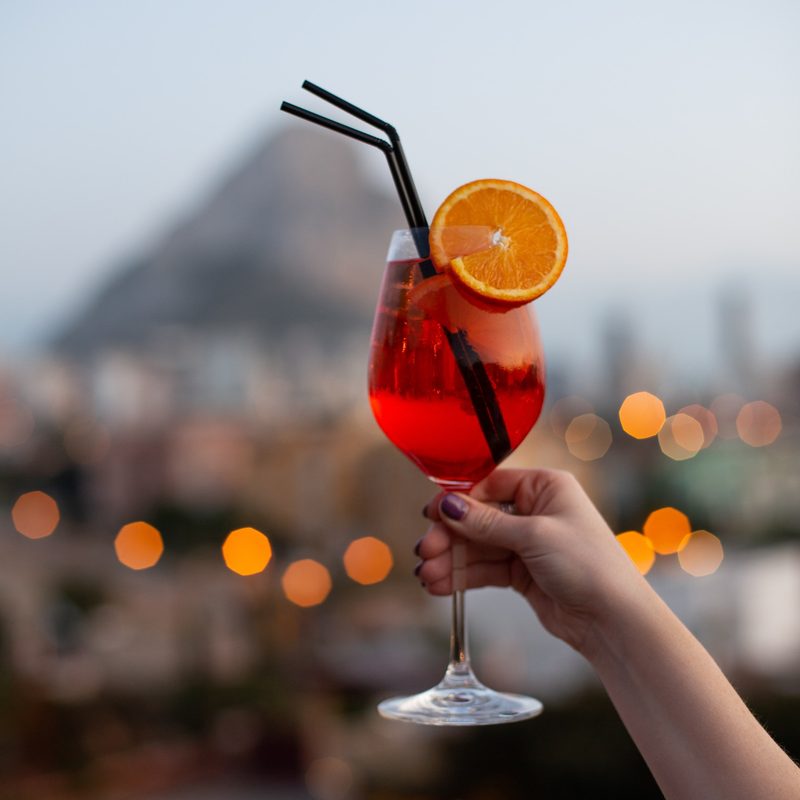 Person holding a glass of Aperol spritz
