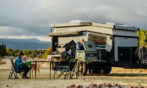 Small family relaxing outdoors with a Boreas Campers EOS-12 camper trailer.
