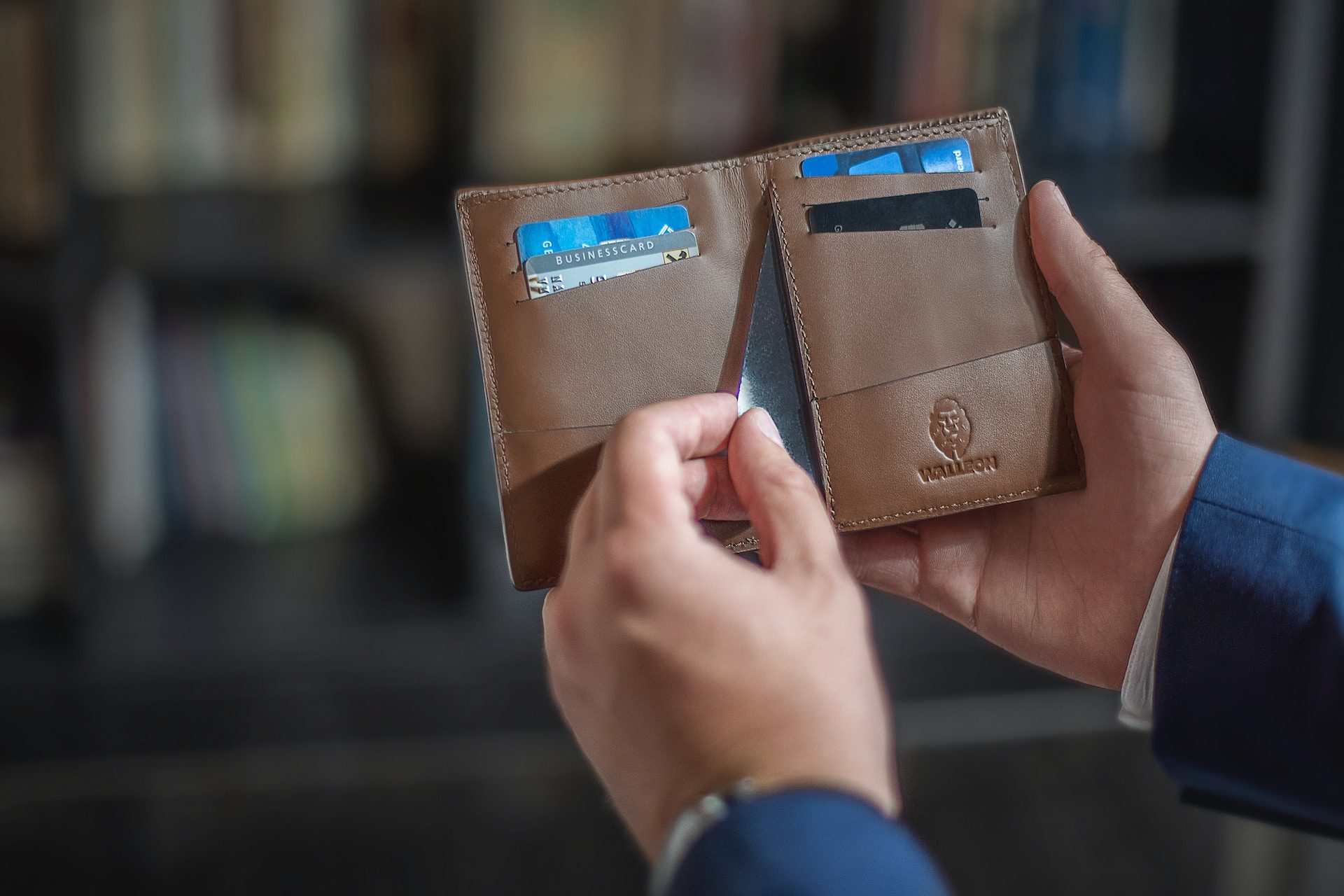 Closeup of a man's hands pulling a card out of his wallet