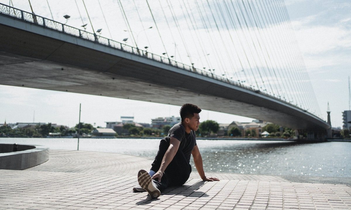a man doing a glute twist outside