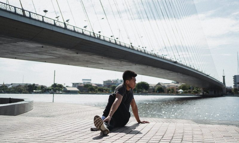 a man doing a glute twist outside