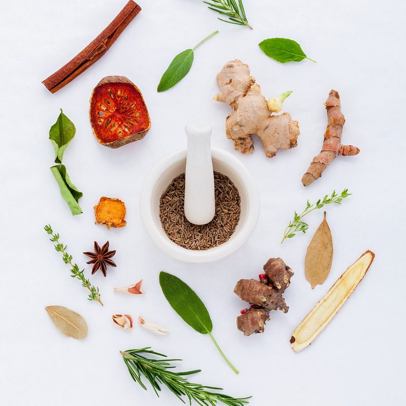Herbs surrounding a mortar and pestle