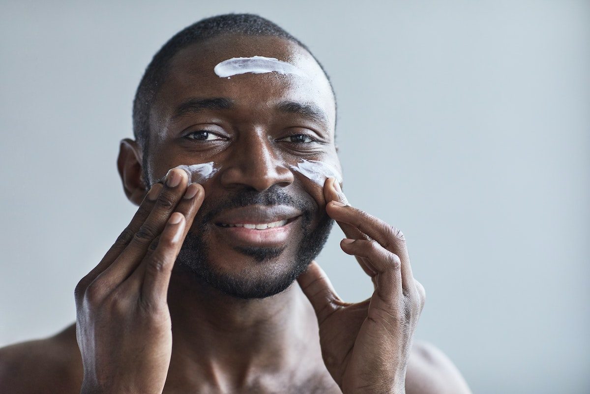 a man applying skincare products to face