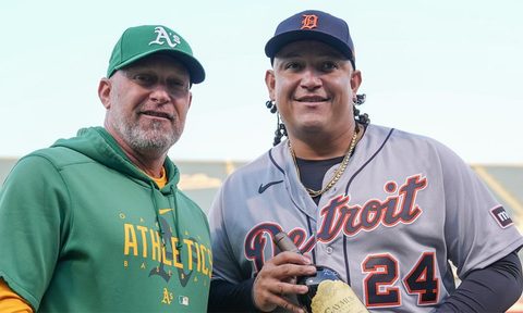 Miguel Cabrera holding the wine alongside the manager of the Oakland A's.