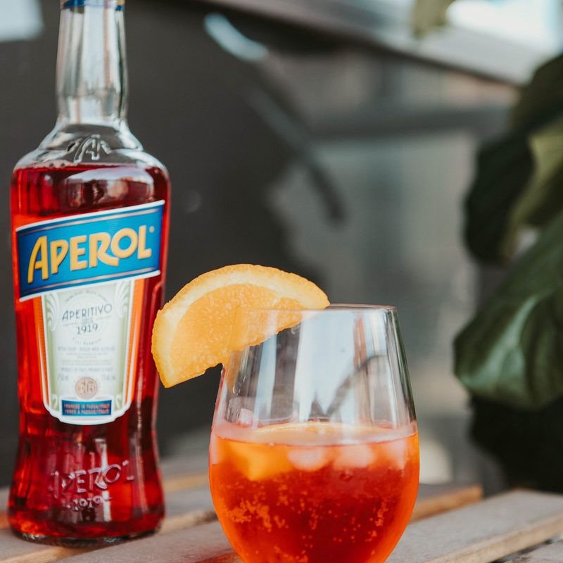 Bottle of Aperol with a glass of Aperol spritz