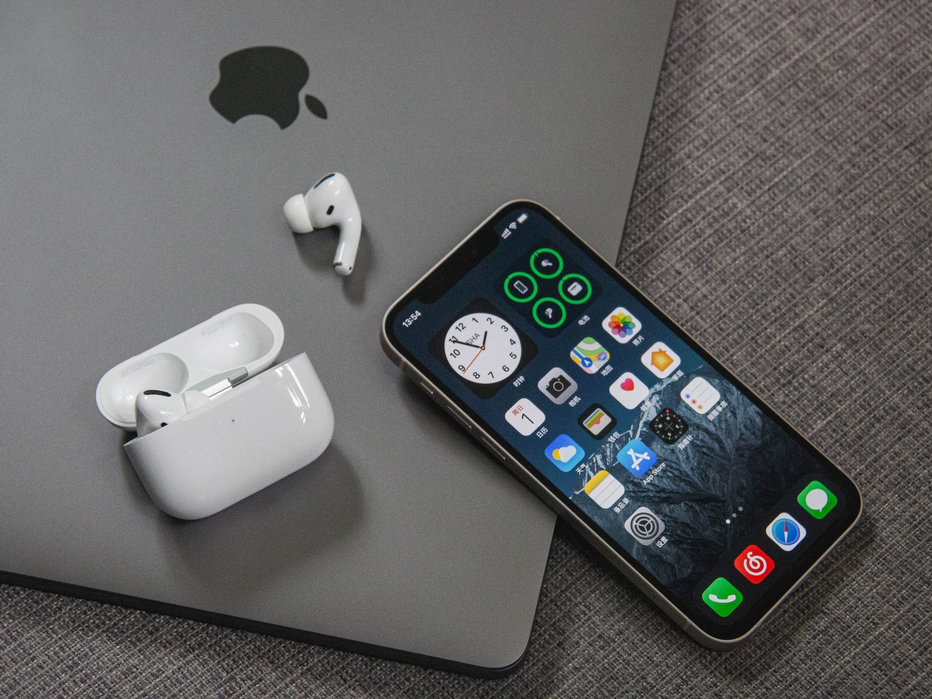 An iPhone and airpods resting on an iPad.
