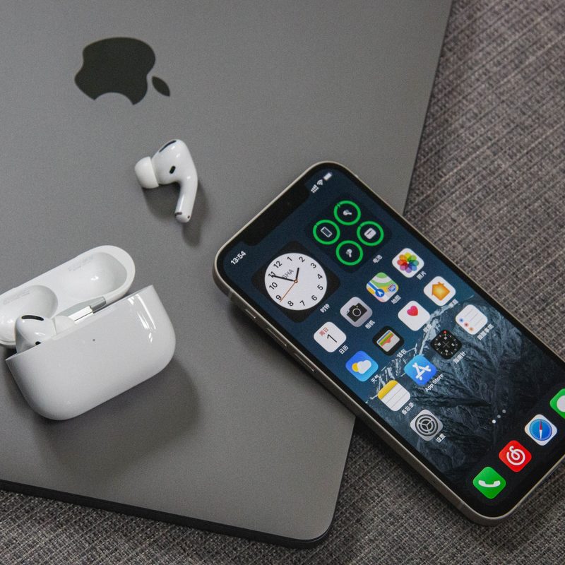An iPhone and airpods resting on an iPad.