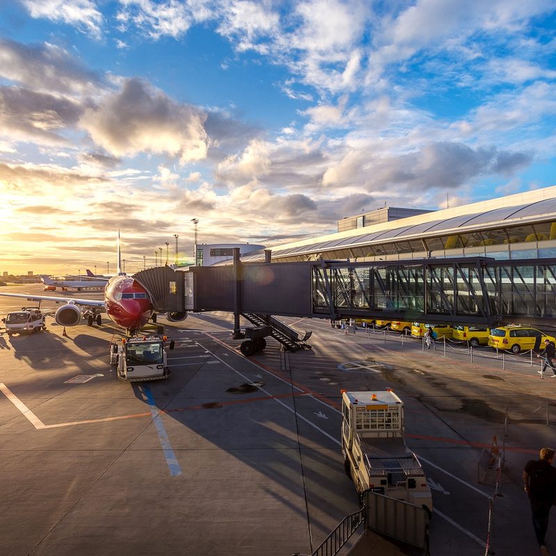 An airport from the exterior, showing an airplane connected to the terminal