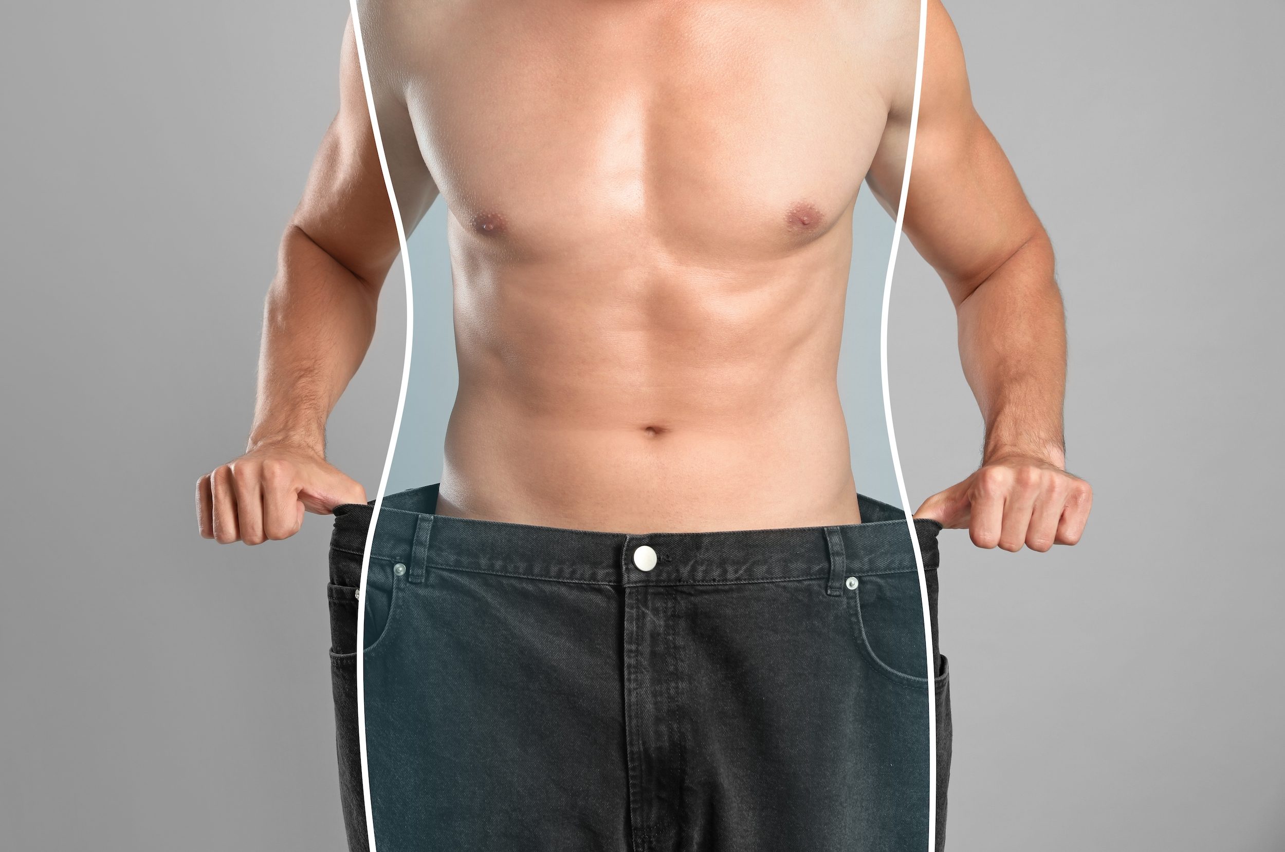 Closeup view of man with slim body in oversized jeans on grey background. Weight loss.