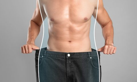 Close-up view of man with slim body in oversized jeans