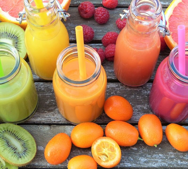 Fresh fruits cut in half on display with vibrant colors and smoothies