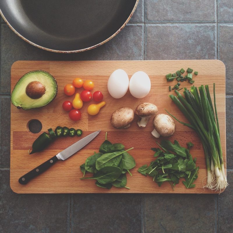 Overhead view of cutting board with food and knive