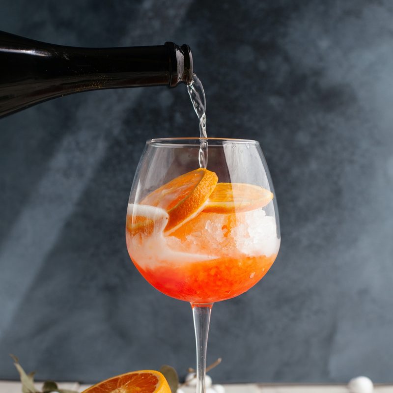 Aperol spritz with half an orange on the table