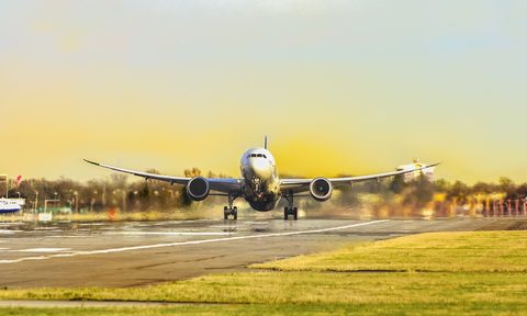 airplane taking off on a runway at sunset