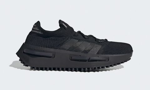 A side angle of the Adidas NMD_S1 shoes in black against a gray background.