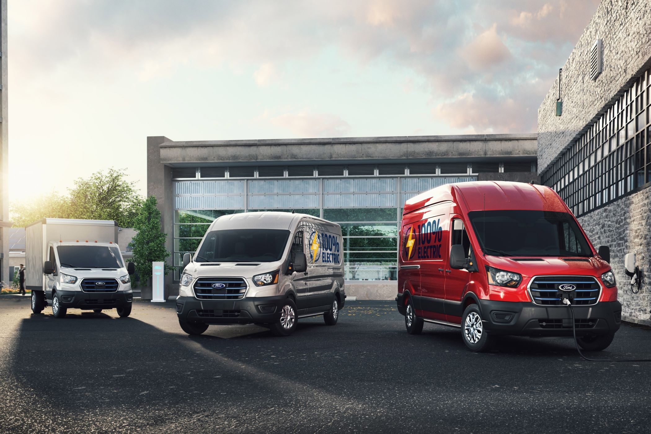 Three Ford E-Transit models parked outside.