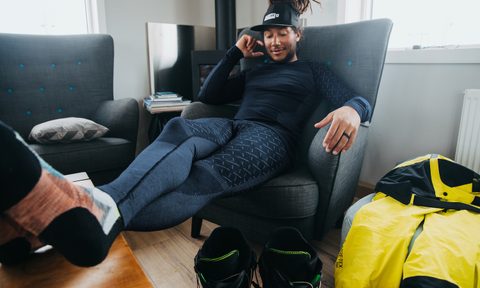 A man sits in a chair wearing the ODLO x Burton Slokar Baselayers