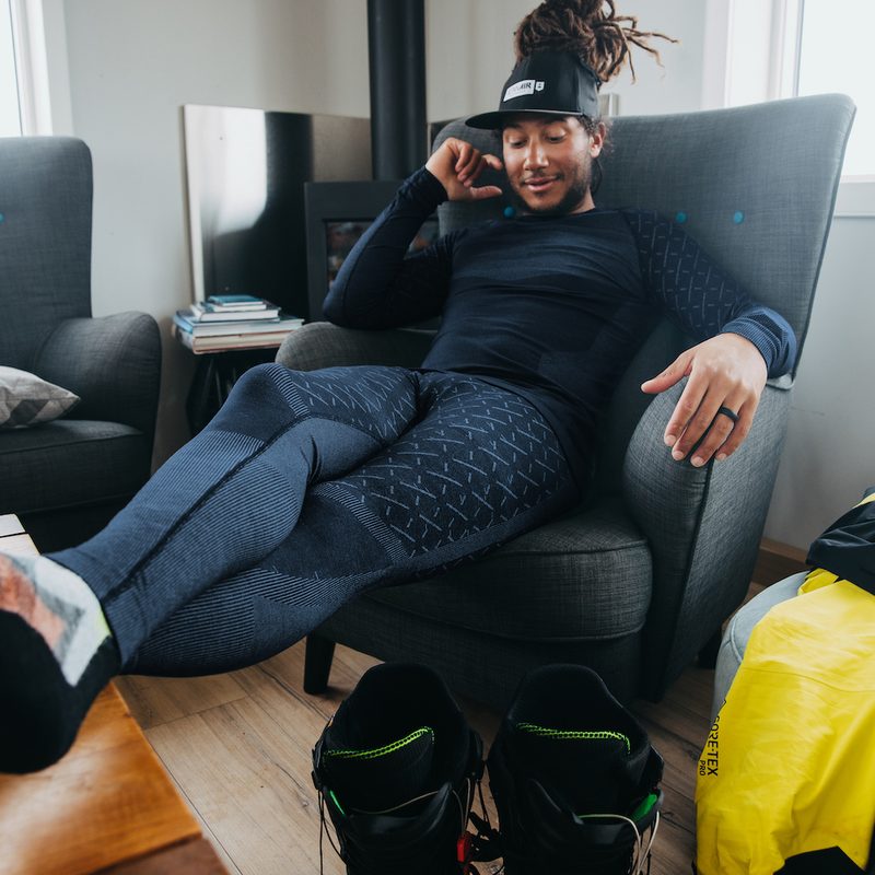 A man sits in a chair wearing the ODLO x Burton Slokar Baselayers