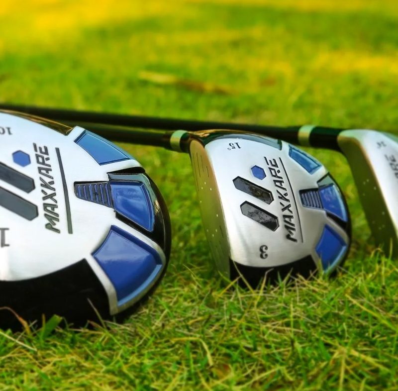 The MaxKare driver, 3-wood, and hybrid club laid out on the grass.