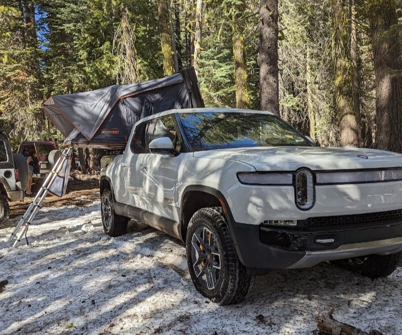 Rivian R1T on a camp site with a roof tent