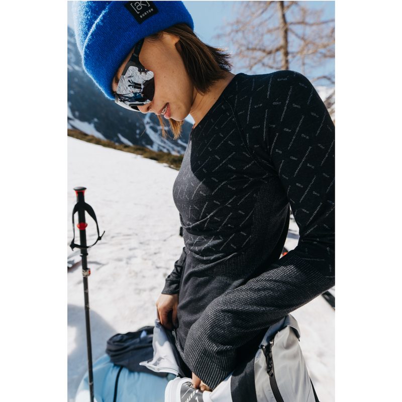 A woman wearing a ODLO x Burton Slokar Baselayers on the snow.