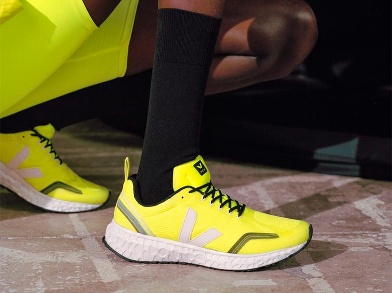 Kneeling in the Veja Condor Mesh Jaune fluorescent yellow and white shoes.