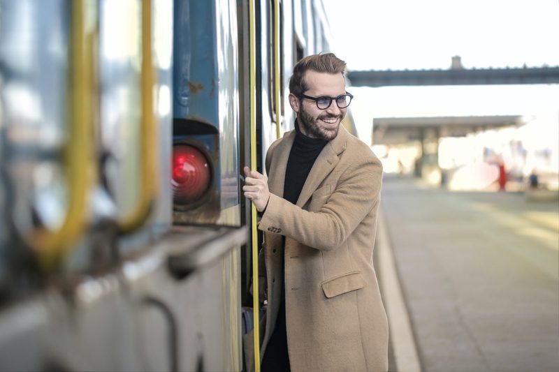Man in cashmere coat getting on a train