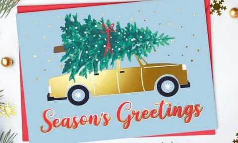 Christmas card showing a tree strapped to a car roof.