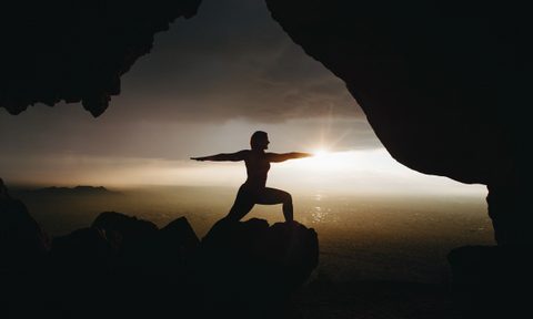 Silhouette yoga pose on a clifftop
