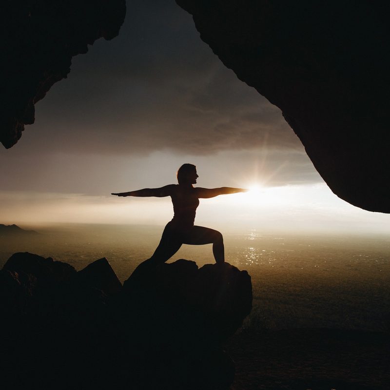 Silhouette yoga pose on a clifftop