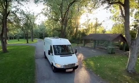 YouTuber DualEx's Mercedes Sprinter conversion campervan driving through a park.