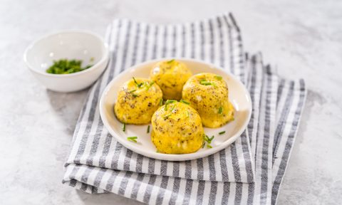 Serving egg bites garnished with fresh chives on a white plate