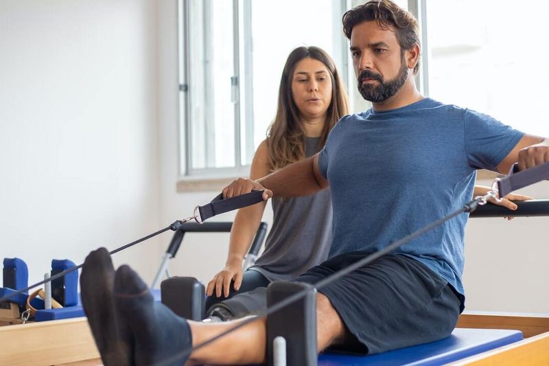 Man using Pilates reformer.