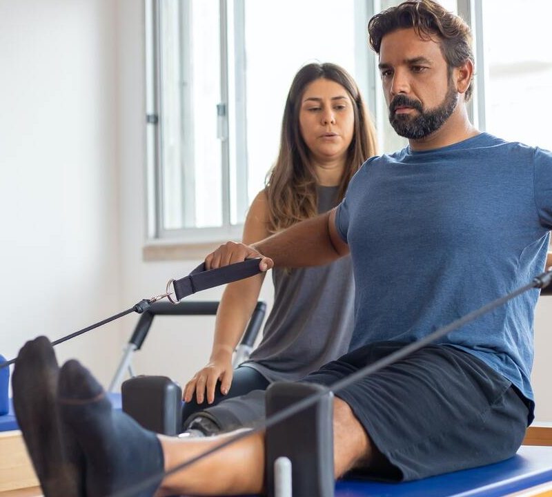 Man using Pilates reformer.