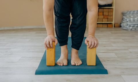 Man doing Pilates with yoga blocks.