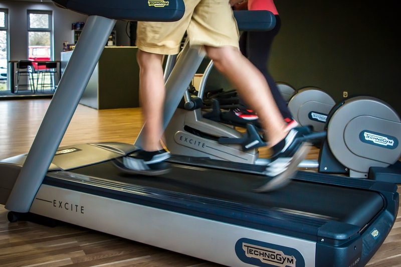 Person in shorts and tennis shoes walking on treadmill