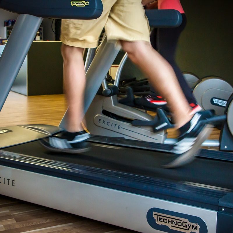 Person in shorts and tennis shoes walking on treadmill